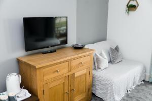 a television sitting on top of a wooden stand next to a couch at The Lakeside in Redcar