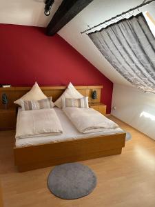 a bedroom with a large bed with a red wall at Gasthof zur Post Hotel - Restaurant in Breckerfeld