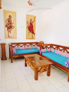 Pendo Villas Diani Beach في شاطئ دياني: غرفة بسريرين وطاولة قهوة