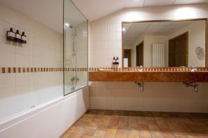 a bathroom with a shower and a sink and a mirror at Hotel Màgic Ski in La Massana