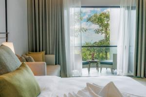 a hotel room with a bed and a large window at Discovery Samal in Samal