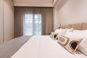 een groot wit bed in een kamer met een raam bij Phaedrus Living: Executive Flat Kolonaki in Athene