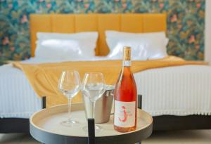 een fles wijn en twee glazen op een tafel in een slaapkamer bij Hôtel & Résidence San Roccu in Saint-Florent