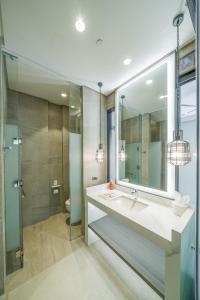 a bathroom with a sink and a mirror and a shower at Discovery Samal in Samal