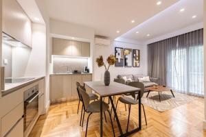 een keuken en een woonkamer met een tafel en stoelen bij Phaedrus Living: Executive Flat Kolonaki in Athene