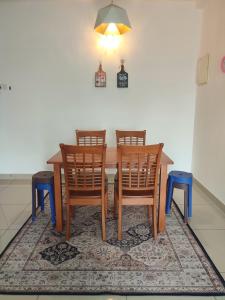 a dining room with a table and chairs on a rug at KAF Homestay for Musliim only with Pool, 3 Bedroom, Smartkey concept, Kids Trampoline, Game console, WIFI, Durioo in Perai