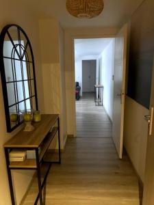 Zimmer mit einem Flur mit einem Tisch und einem Spiegel in der Unterkunft Appartement familial 3 chambres 15min PARIS metro in Bois-Colombes