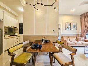 依斯干達公主城的住宿－Meridin Medini Suite by Nest Home【LEGOLAND】，厨房以及带木桌和椅子的客厅。