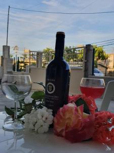 a bottle of wine and two glasses on a table at Arlind's Apartaments in Vlorë
