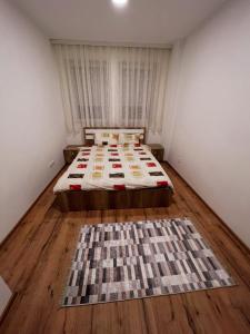 a bedroom with a bed with a rug on the floor at Cinema Relax Apartament in Prishtinë