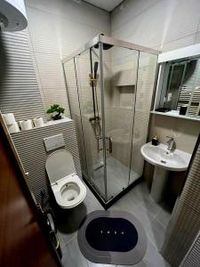 y baño con ducha, aseo y lavamanos. en Cinema Relax Apartament en Pristina