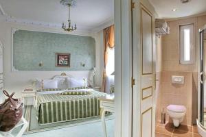 1 dormitorio con cama y aseo en Queen's Astoria Design Hotel, en Belgrado