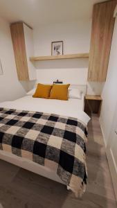 a bedroom with a bed with a black and white checkered blanket at Premium mobile home Maslina - Oaza mira in Drage +12 photos