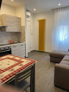 cocina y sala de estar con mesa y sofá en La Divina Holiday, en Rávena