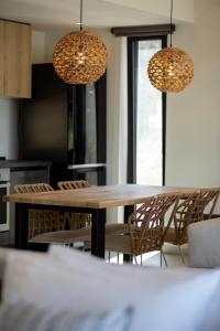 een eetkamer met een tafel en stoelen en 2 verlichting bij Amahle Luxury Villas 2023 in Andipáta Erísou