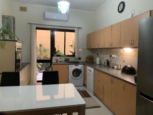 a kitchen with a washing machine and a dishwasher at Caris Gem in Birżebbuġa