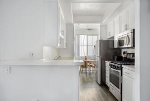 a kitchen with white cabinets and a stainless steel refrigerator at Century City 2br w bbq wd nr mall shops LAX-1063 in Los Angeles