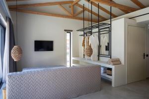a dressing room with a bench and a tv at Amahle Luxury Villas 2023 in Andipáta Erísou