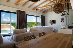 een woonkamer met een houten tafel en stoelen en een woonkamer bij Amahle Luxury Villas 2023 in Andipáta Erísou