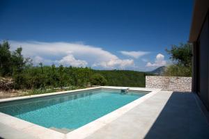 a swimming pool in front of a house at Amahle Luxury Villas 2023 in Andipáta Erísou