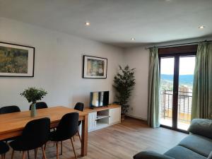 Sala de estar con mesa de comedor y TV en Apartamentos Miguel Angel, en Beteta