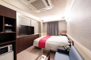 a hotel room with a bed and a tv at Hotel Next II-Adult Only in Sendai