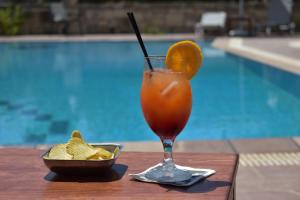 una bebida con una naranja y un tazón de patatas fritas en Dimitris Villa Hotel, en Matala