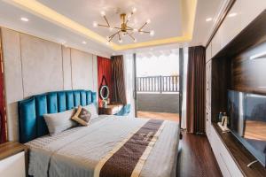 ハロンにあるTâm Thắng Hotelのベッドルーム1室(ブルーヘッドボード付きの大型ベッド1台付)