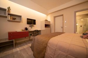 - une chambre avec un lit, un bureau et une télévision dans l'établissement San Nicolicchio - Luxury Guest House, à Tarente