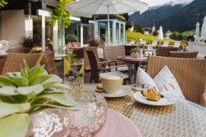 a table with a cup of coffee and a plate of food at Hotel Pfeifer in Gaschurn