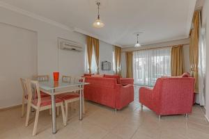 a living room with a table and red chairs at Private Pool,near to The Land of LEGEND in Belek