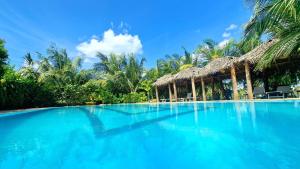 een zwembad met blauw water en palmbomen bij ITALIAN GUEST in Trincomalee