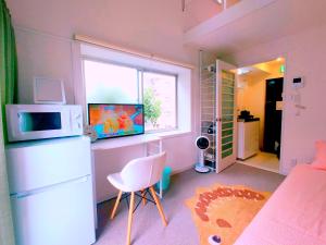 Habitación pequeña con nevera y ventana en Glen Stage 中浦和, en Saitama