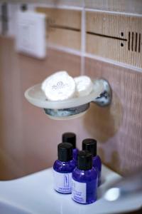 a group of three bottles of soap on a sink at Hotel Oaz in Golem