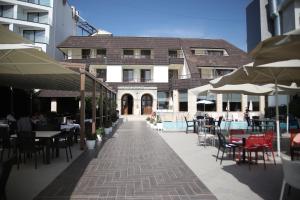 een patio met tafels en stoelen en een gebouw bij Hotel Oaz in Golem
