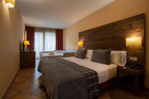 um quarto de hotel com uma cama e um sofá em Hotel Màgic Ski em La Massana