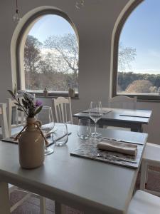 a table with glasses and a vase with flowers on it at Casale Dei Pini - Nature Room in Martina Franca