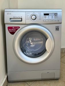 uma máquina de lavar roupa está sentada num quarto em Neema Executive Suites Ngong RD with Balcony em Nairobi