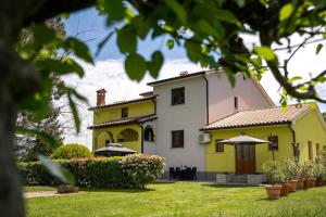 een geel en wit huis met een tuin bij Apartman Ela Vi in Kršan