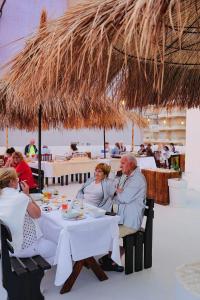 a group of people sitting at a table in a restaurant at Hotel Havana in Sarandë