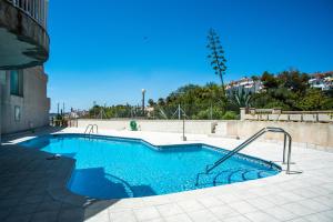 una piscina de agua azul en un edificio en Casa Cala Balmins, en Sitges