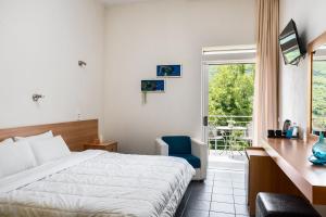 um quarto com uma cama, uma secretária e uma janela em Gefiri Plakas Hotel by Konnect, Tzoumerka em Plaka
