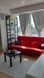 a red couch in a living room with a table at ATCA House in Bucharest