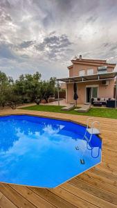 a blue swimming pool in front of a house at Villa Lagonisi in Aghia Marina