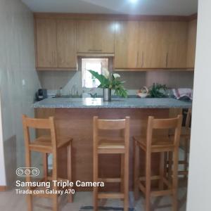 une cuisine avec un comptoir avec des chaises et un îlot dans l'établissement Casa do Mateus, 