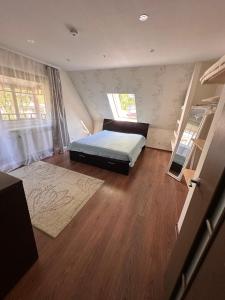 a bedroom with a bed and a wooden floor at Svetes house - Garden & BBQ & Parking in Liepāja