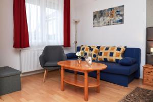 a living room with a blue couch and a table at Apartman Brigitte Bükfürdő in Bük