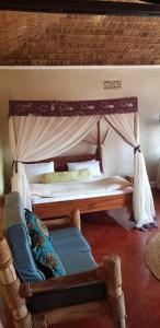 a bedroom with a canopy bed and a chair at Rudi House in Msaranga
