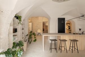 a kitchen and living room with a table and stools at April1550 Boutique Hotel in Ljubljana