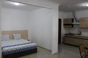 a bedroom with a bed and a kitchen in it at Guest House Dostar - Жағажай Үй Достар in Aktau